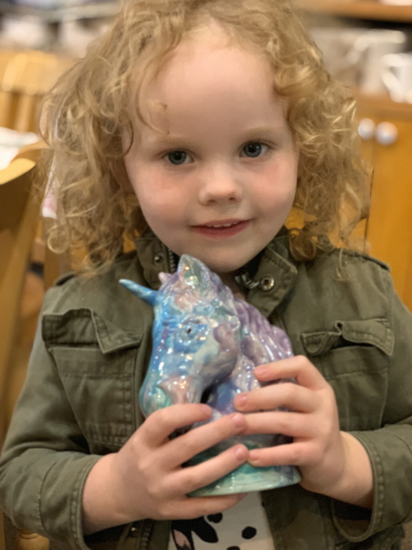 Cute little girl holding a unicorn clay toy