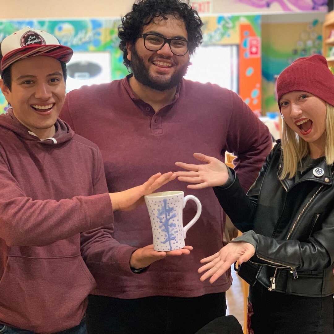 People holding a cup and smiling to the camera