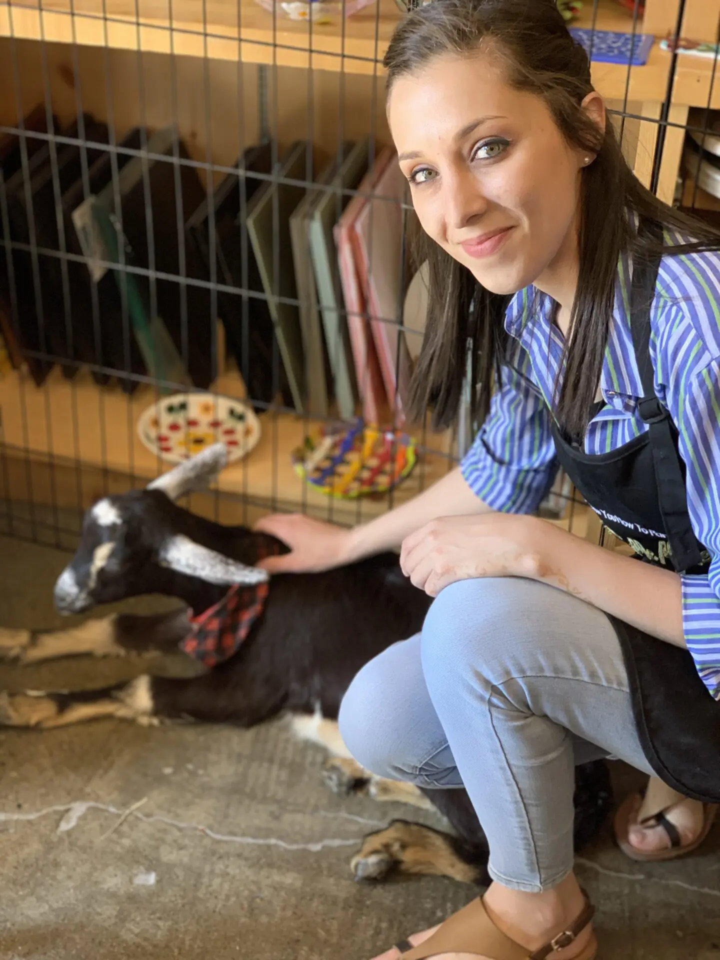 Teenager girl is petting a baby goat