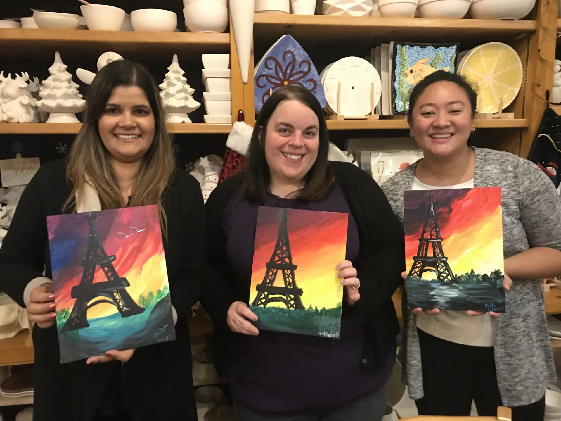 Group of Women holding pairs tower painting and smiling for camera