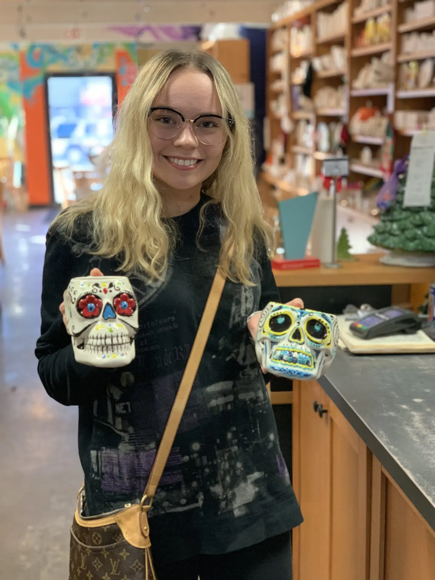 Young beautiful woman holding skeleton head mugs