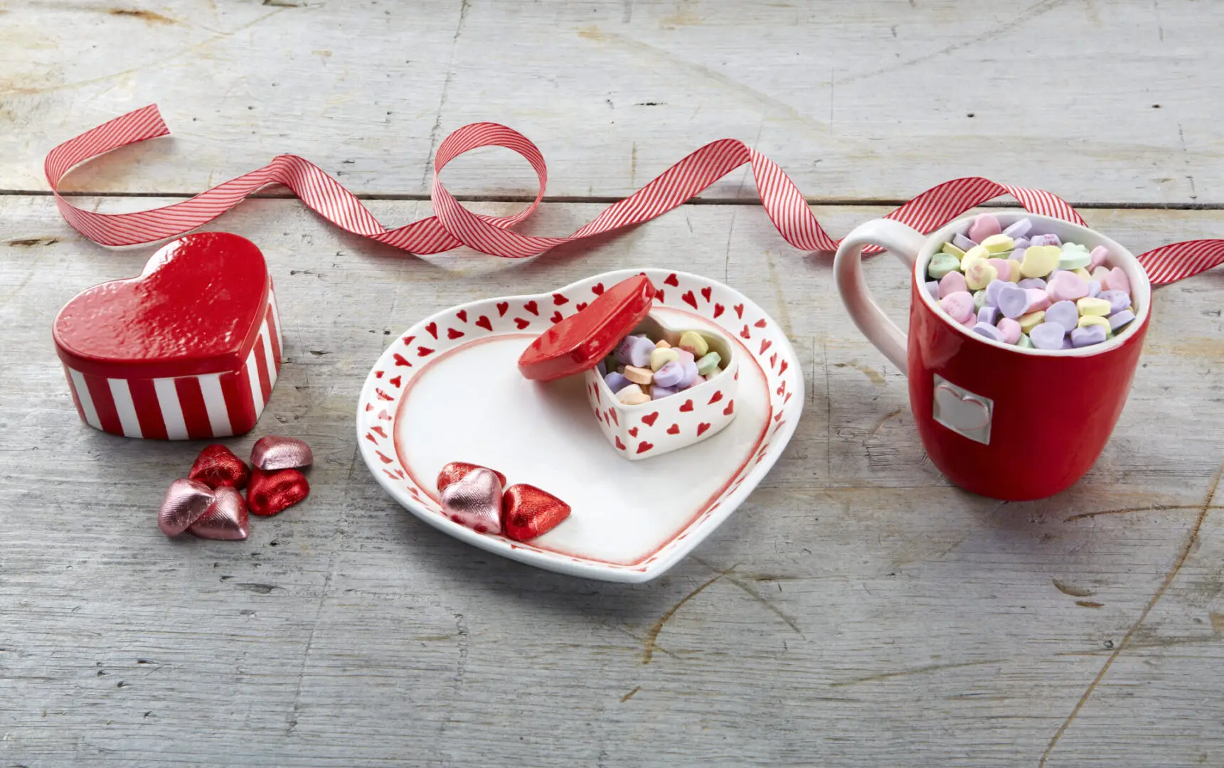 heart-shaped chocolates and mallows in a plate, a cup, and containers